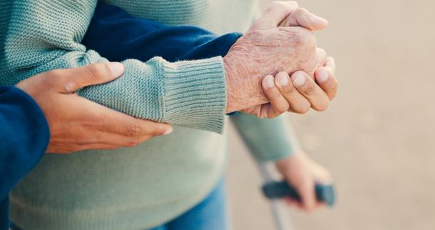 Younger person supports an older person. Credits: Shutterstock